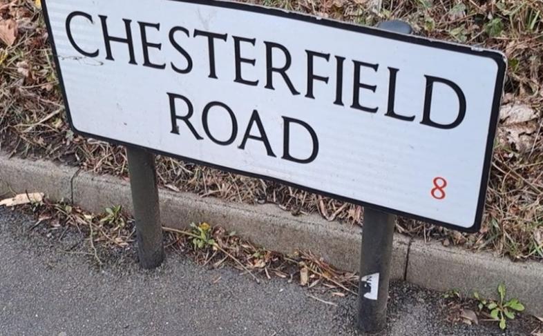 A white road name sign with Chesterfield Road in black