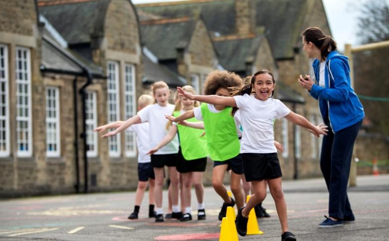 Children running and playing in school playground,