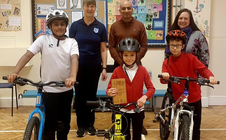 Jo Searle (Head of PE), Cllr Mazher Iqbal, Gillian Briggs (Head Teacher), with 3 pupils and their bikes