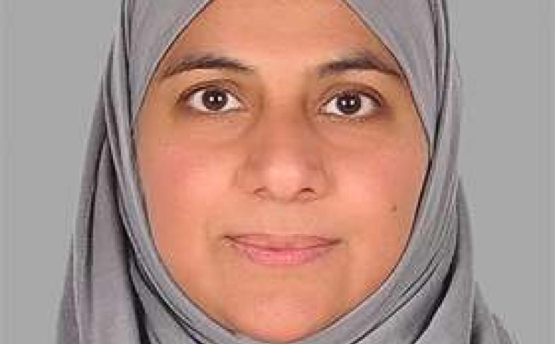 A close-up image of Faiza Mobin staring straight ahead at the camer aand smiling