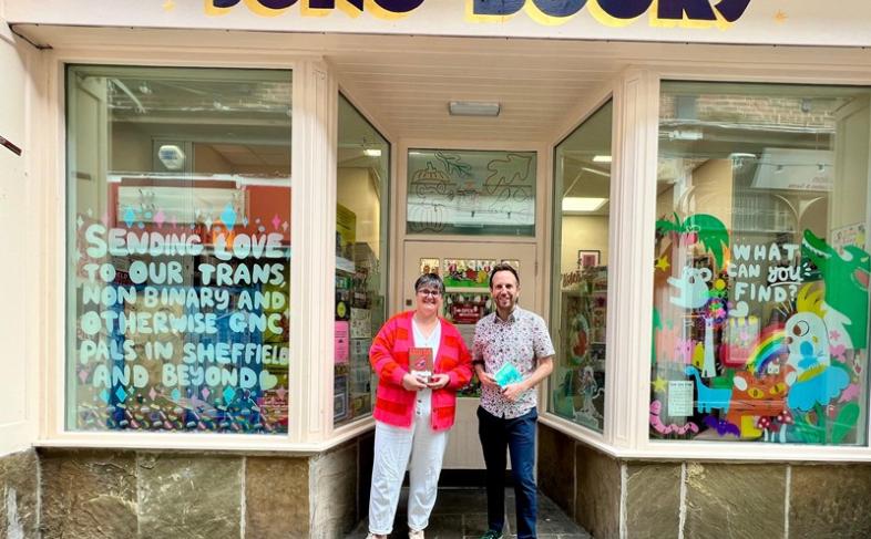 Cllr Ben Miskell smiles with one of the owners of Juno's Books outside the shop