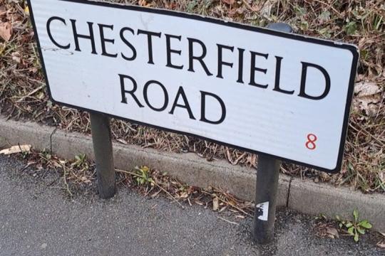 A white road name sign with Chesterfield Road in black