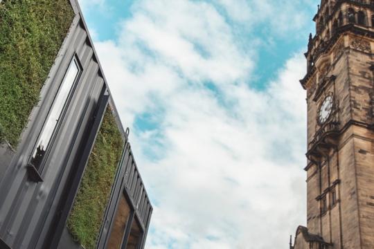 Image of the grey Fargate containers with the Town Hall clock in the background