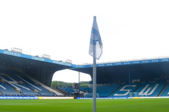 A view inside Hillsborough Stadium. View looking onto the football pitch with empty stands in the background and a flag in front of the camera.