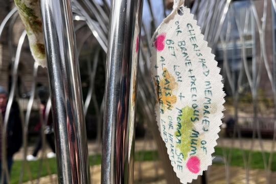 A leaf made of fabric with a memorial written on it 