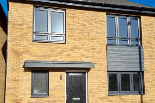 A brick house with black windows and doors 