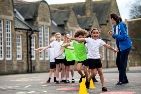 Children running and playing in school playground,