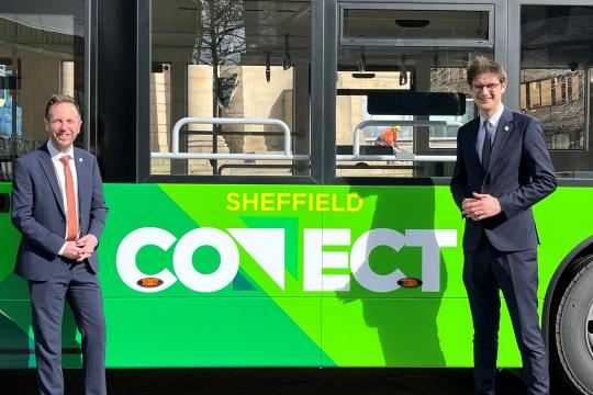 Cllr Ben Miskell and Cllr Tom Hunt standing in front of a green Sheffield Connect fully electric bus