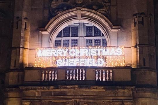 Town Hall entrance and balcony. Merry Christmas Sheffield is lit up on the balcony in white and gold lighting