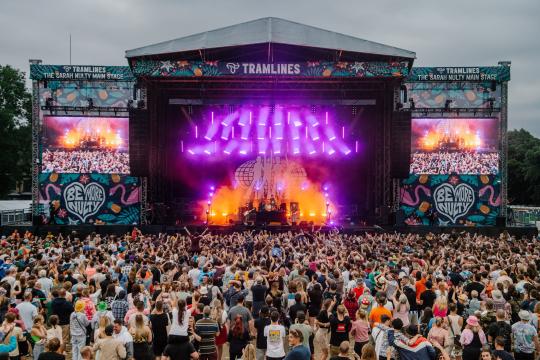 The main stage of Tramlines Festival as a band plays and a large crowd watches