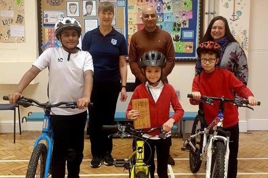 Jo Searle (Head of PE), Cllr Mazher Iqbal, Gillian Briggs (Head Teacher), with 3 pupils and their bikes