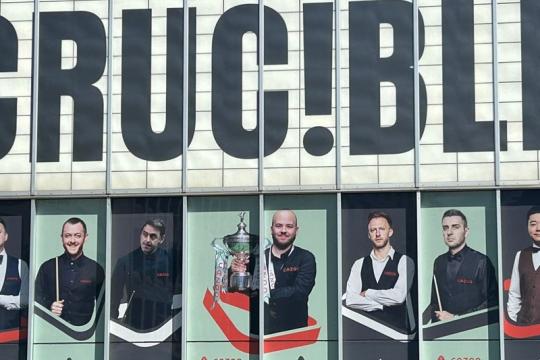 The front of The Crucible theatre displaying posters of snooker championship players.