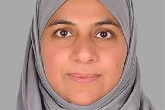 A close-up image of Faiza Mobin staring straight ahead at the camer aand smiling