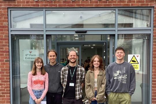 Group of A level students and their teacher standing outside Meadowhead School Sixth Form Centre