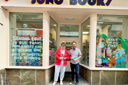 Cllr Ben Miskell smiles with one of the owners of Juno's Books outside the shop