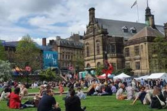 A packed Sheffield Peace Gardens enjoys a busy event in front of the Town Hall on a cloudy day