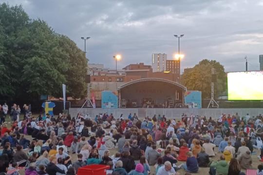 A crowd of people watching a stage on Devonshire Green