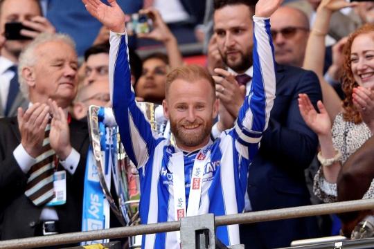 Barry Bannan on the balcony at Wembley Stadium applauding the Sheffield Wednesday fans, he has a victory medal around his neck