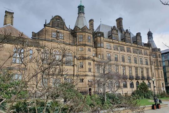 The side of Sheffield Town Hall can be seen with the Peace Gardens in the foreground surrounded by trees